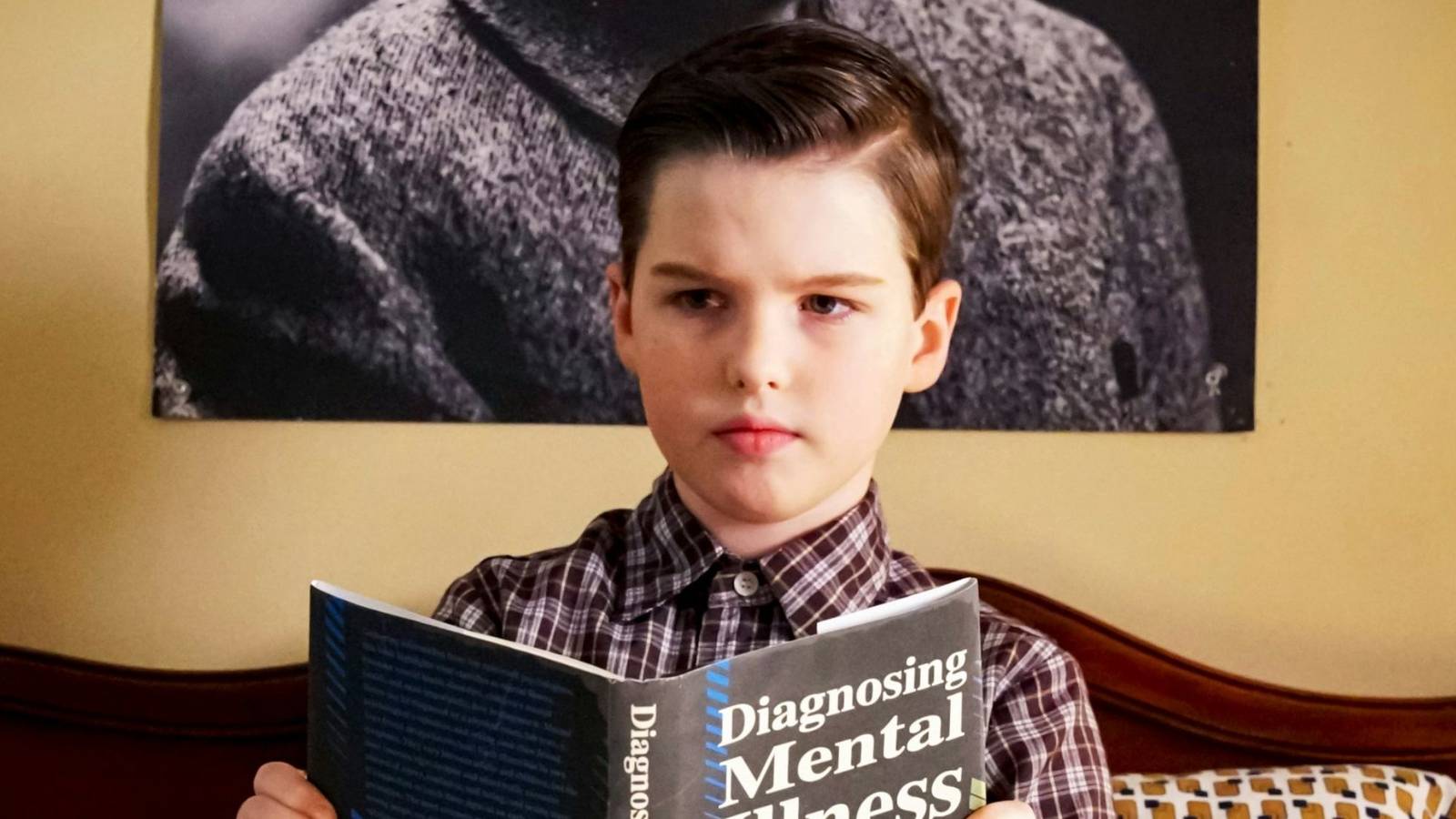 Sheldon reads a book about mental illness in Young Sheldon season 3.