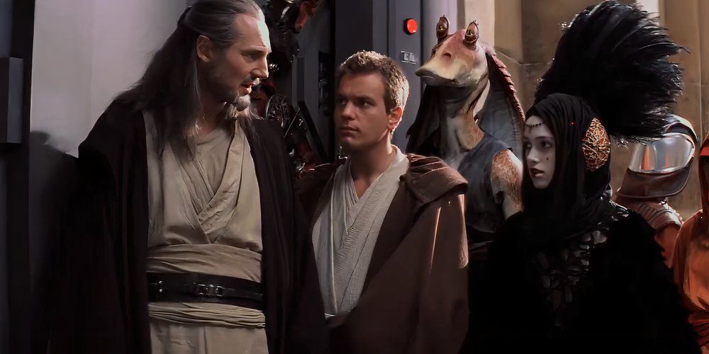 Sabe (Keira Knightley) is speaking with Qui-Gon Jinn (Liam Neeson) and Obi-Wan Kenobi (Ewan McGregor) while disguised as Queen Amidala in Star Wars: Episode 1 -- The Phantom Menace.