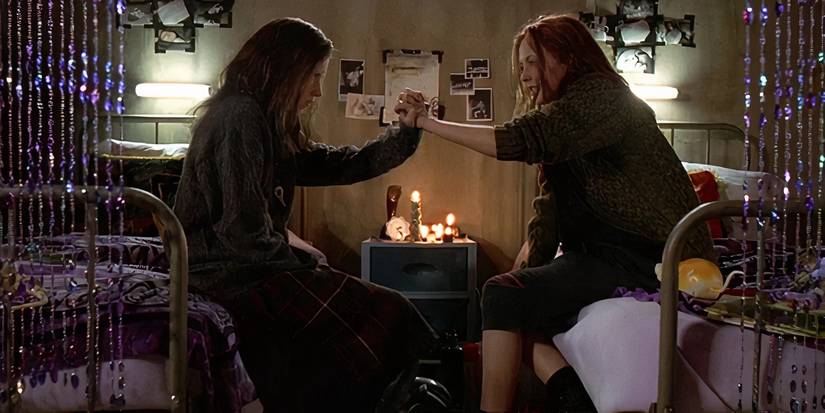 Ginger and Brigitte are shaking hands in their bedroom in Ginger Snaps