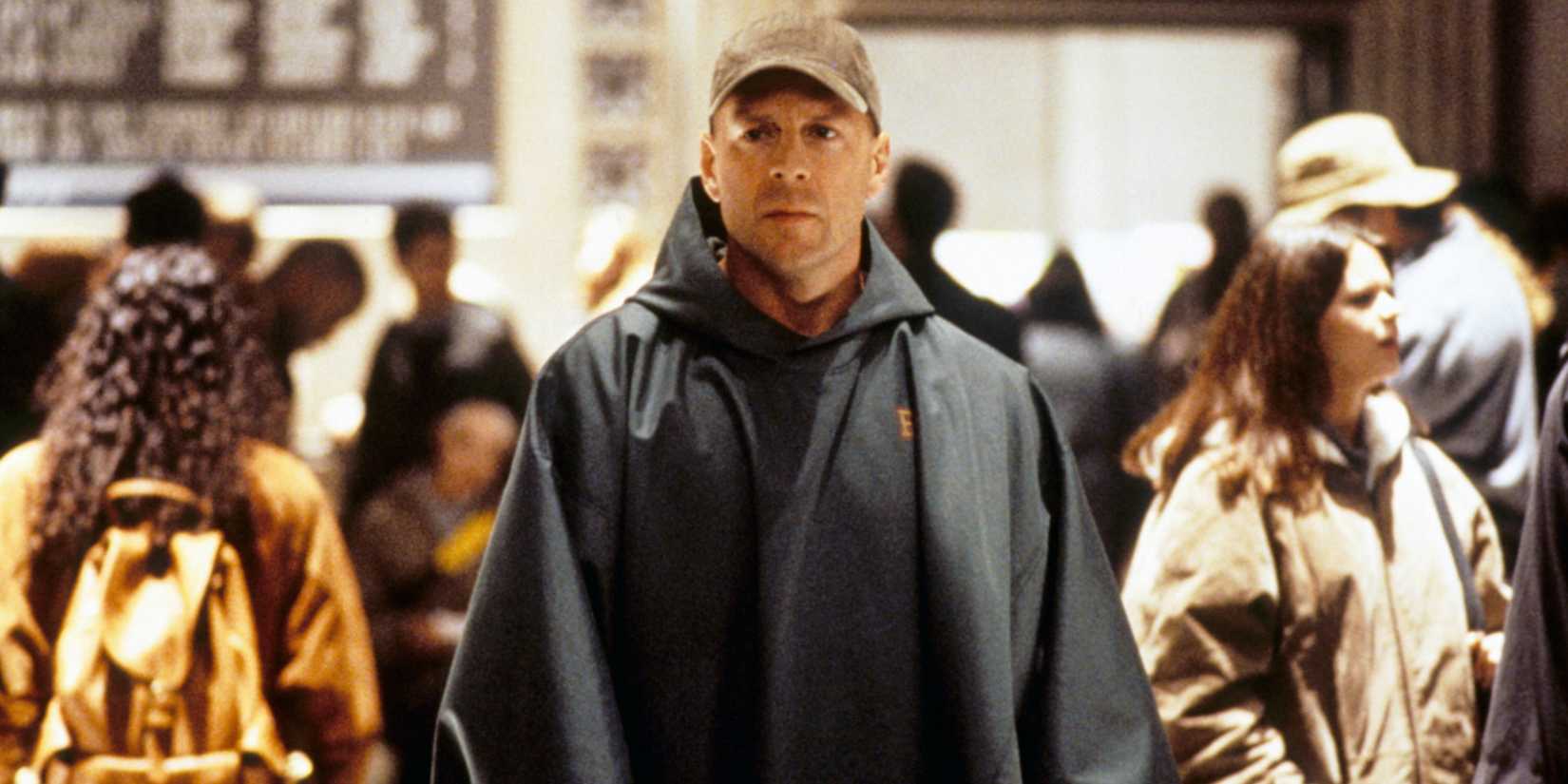 Bruce Willis walks through a crowd in M. Night Shyamalan's Unbreakable