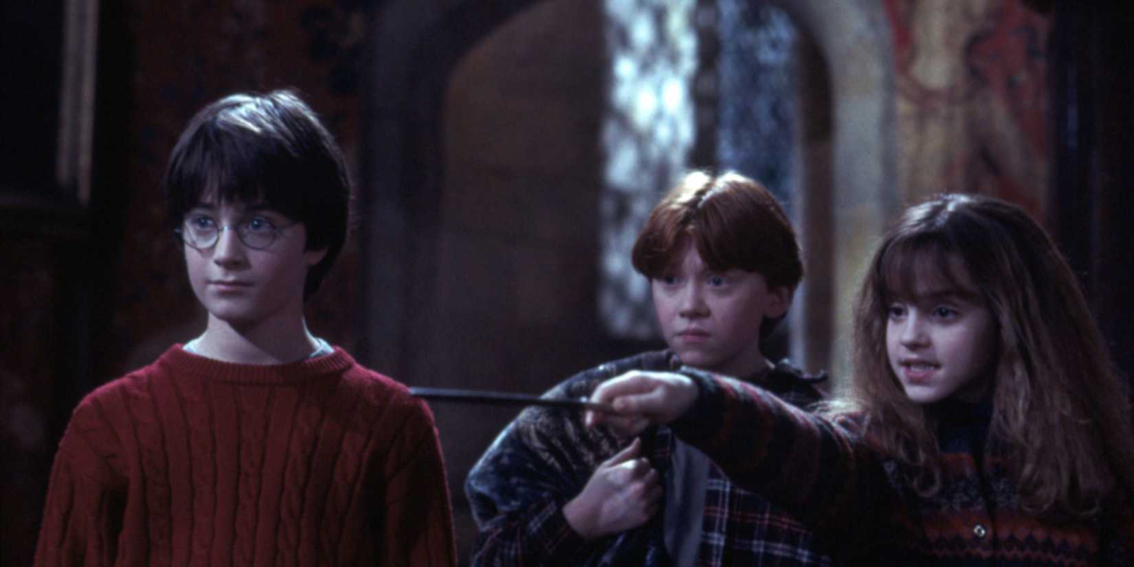 Hermione points her hand while accompanied by Harry and Ron in Harry Potter.