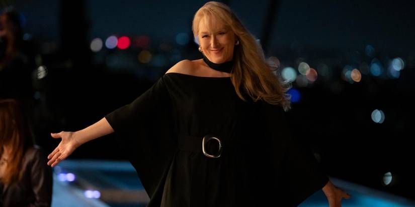 Loretta (Meryl Streep) is held in a black dress by an outdoor swimming pool in only murders in season 4 of the building.