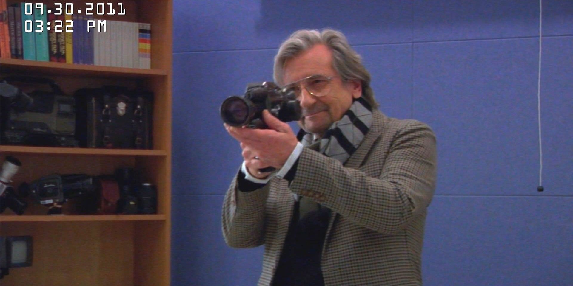 Dudenoff (Griffin Dunne) segurando uma câmera em frente ao olho em Only Murders in the Building.