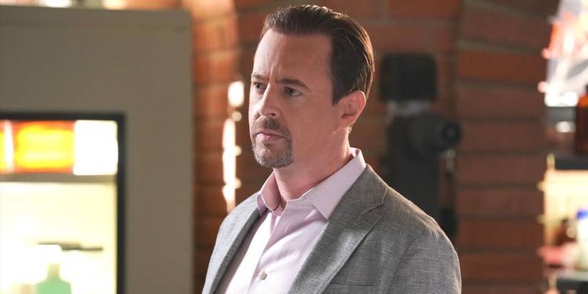 A close-up of Timothy McGee, played by Sean Murray, in a grey suit and white shirt from NCIS