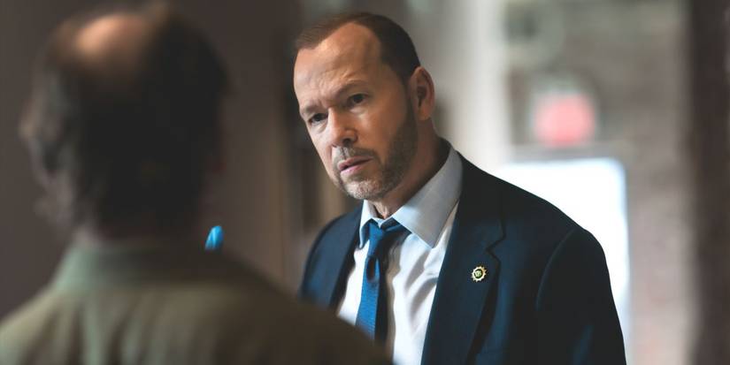 Danny Reagan, played by actor Donnie Wahlberg, wearing a suit speaking to a witness in Blue Bloods