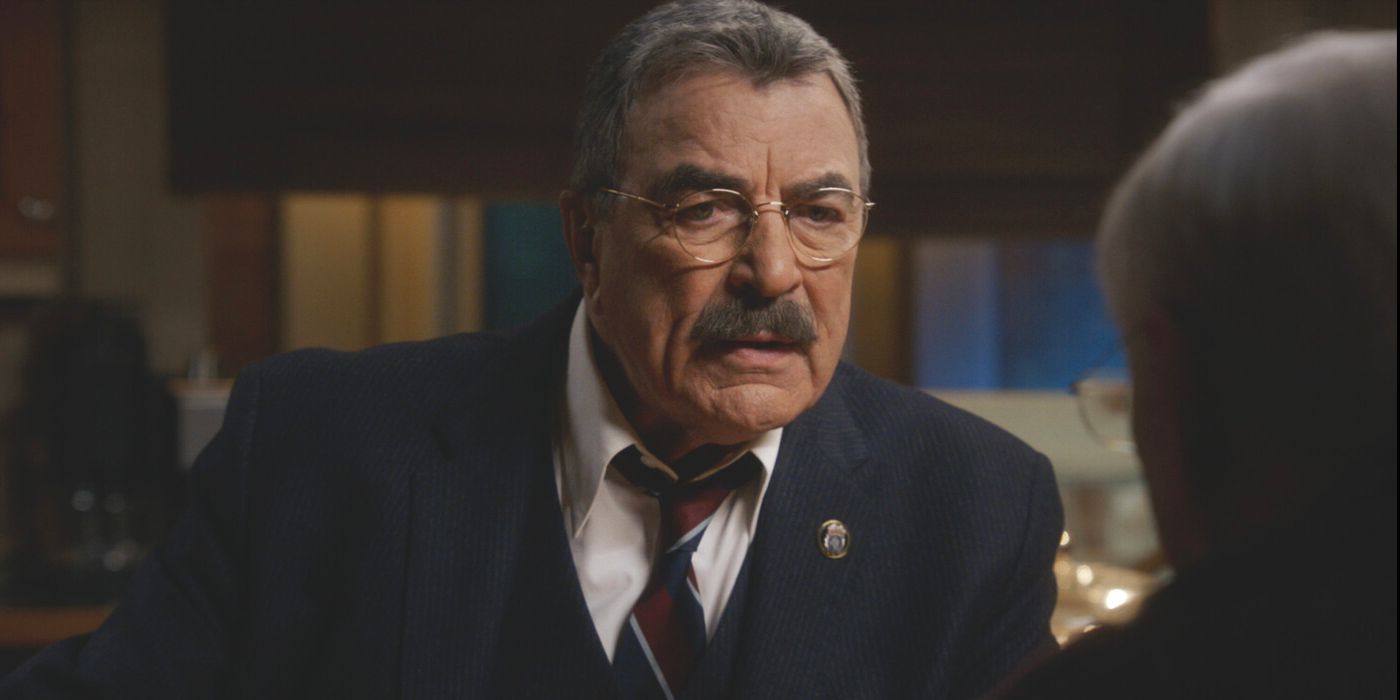 Frank Reagan, played by actor Tom Selleck, sits behind his desk in a suit and tie on Blue Bloods