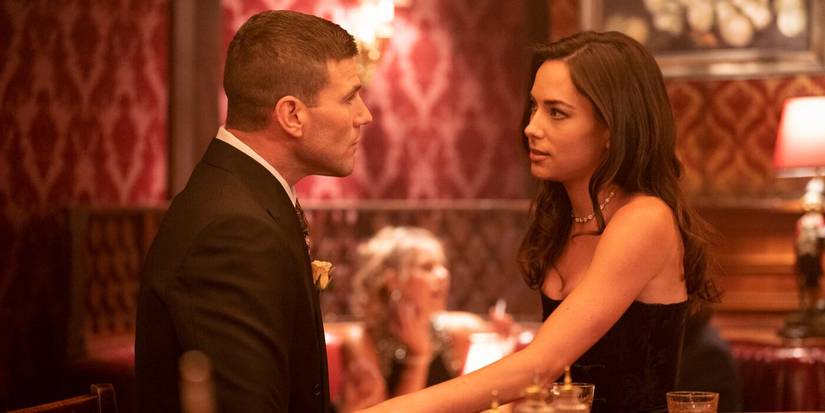 Young Gibbs and Lala Dominguez, in formal wear, sit facing each other at a bar in NCIS: Origins