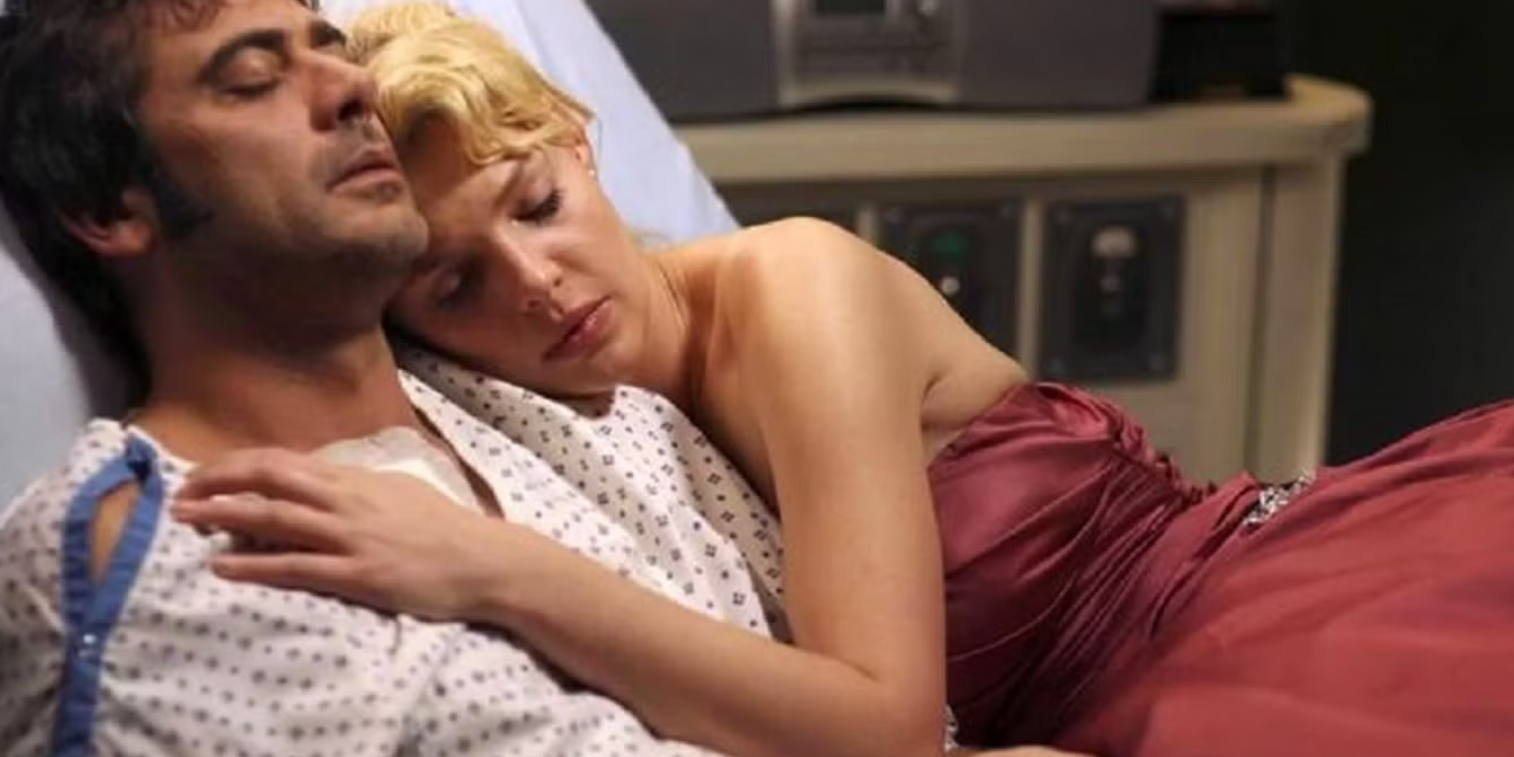 Izzy lays with Denny in his hospital bed in Grey's Anatomy.