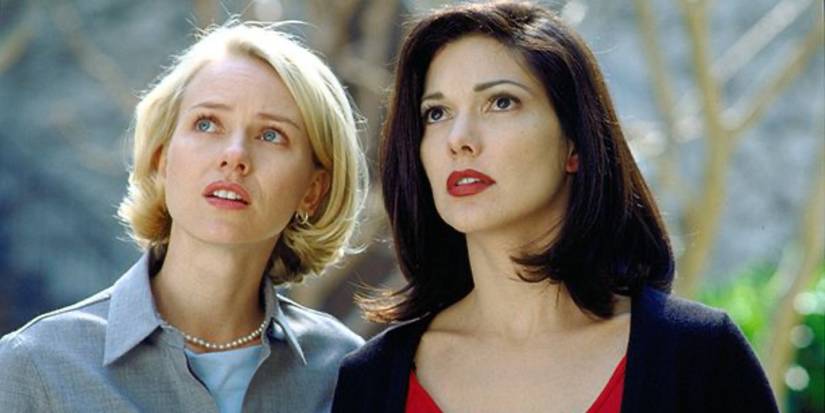 In a scene from Mulholland Drive, Betty and Rita are stood with surprised expressions.