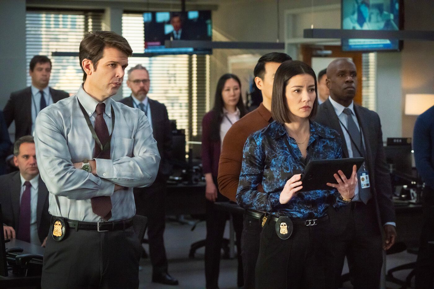 A group of FBI agents stands together in the bullpen in FBI Season 7, Episode 11