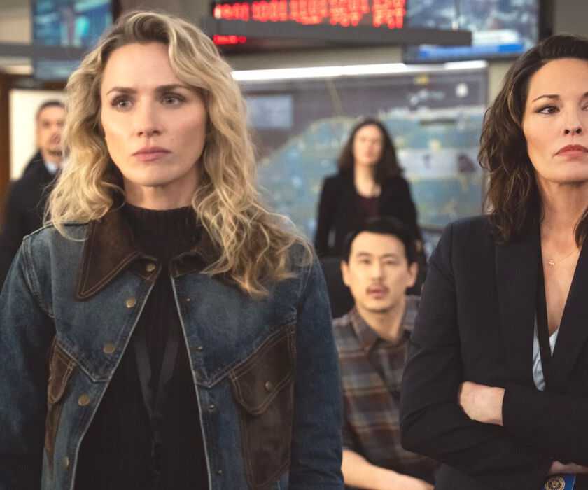 Nina Chase, wearing a denim jacket, stands next to Isobel Castille in the FBI office on FBI TV show