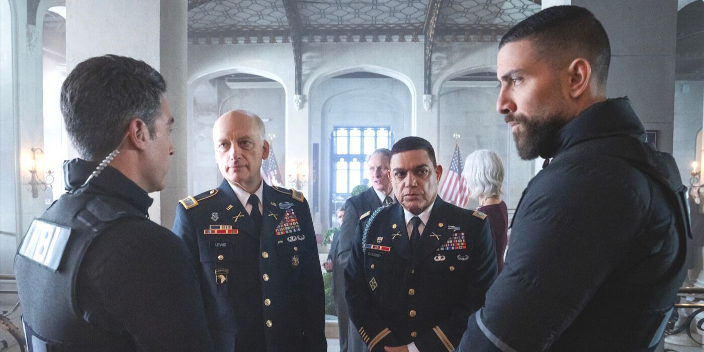 OA looks at Scola, both wearing FBI gear, as they stand in front of two military officers in FBI