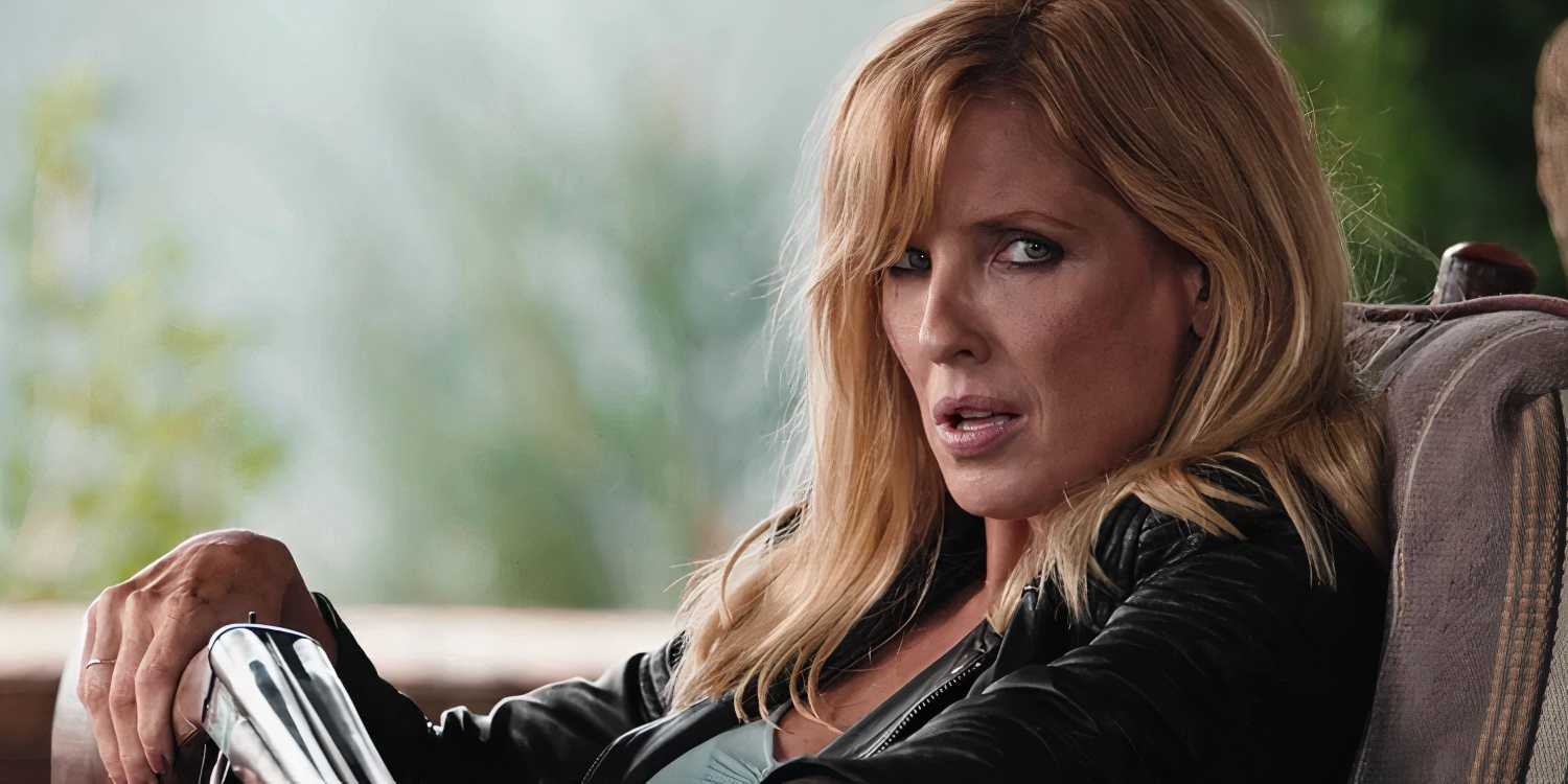 Kelly Reilly looks to her left while holding a double barrel shotgun in Yellowstone