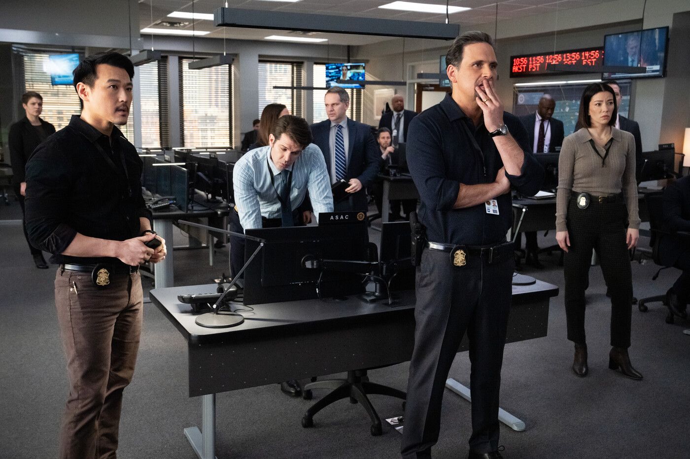 Jubal Valentine stands in the FBI office surrounded by analysts in the CBS TV show FBI