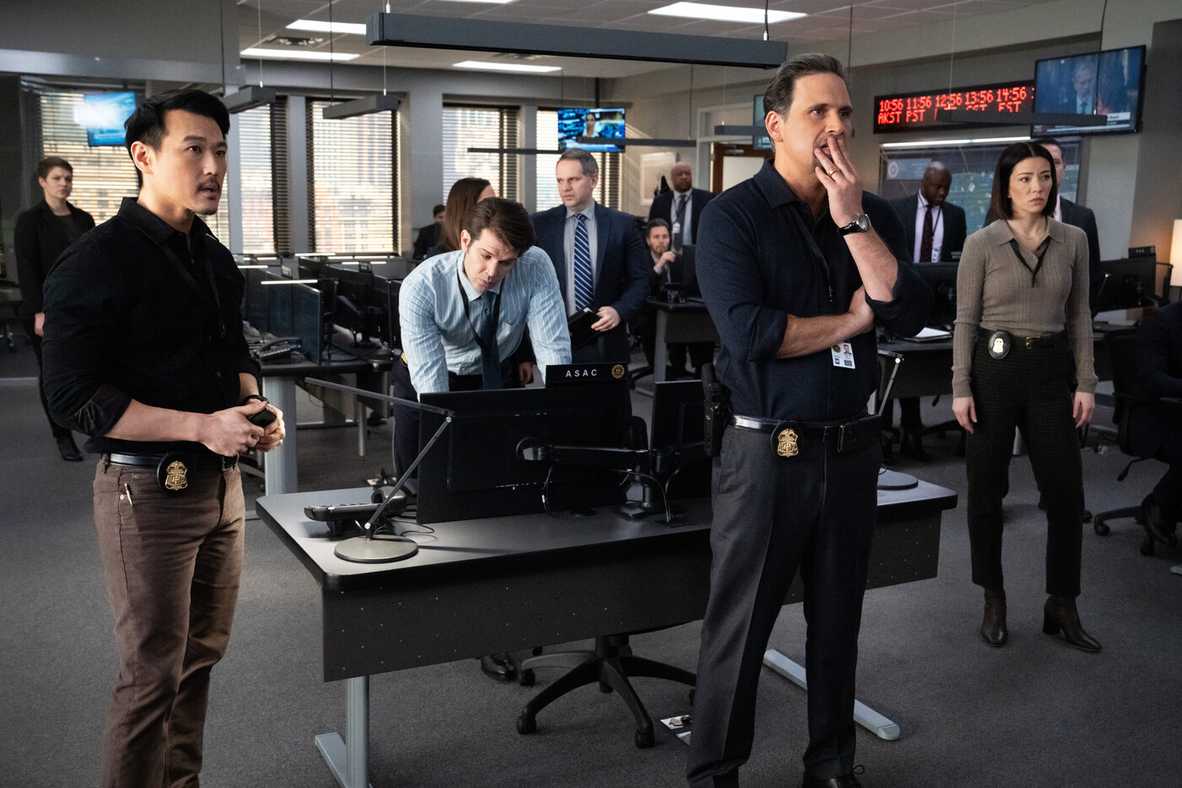 Jubal Valentine stands in the FBI office surrounded by analysts in the CBS TV show FBI