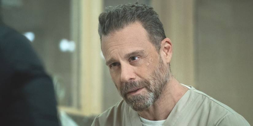 Ray Distefano, played by Matthew Rauch, sits wearing a beige prison uniform in the TV show FBI