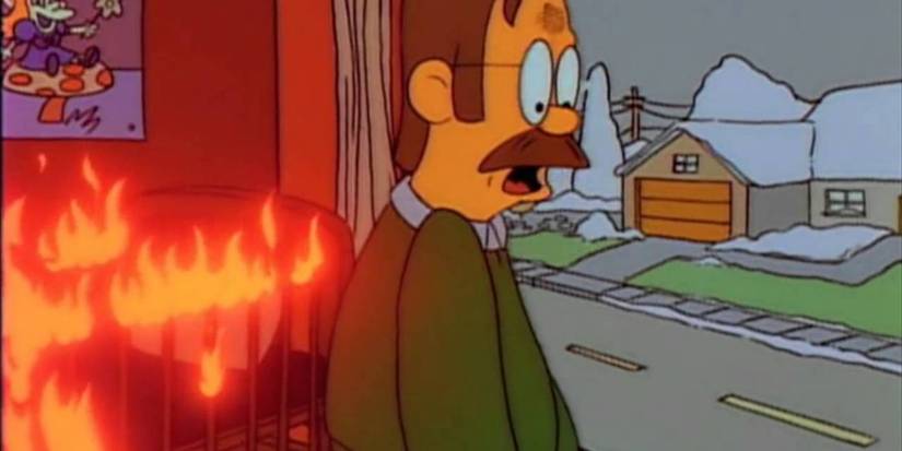 Flanders looks in shock as he tries to save Homer from his house on fire in The Simpsons.
