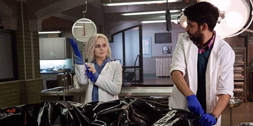 Liv Moore (Rose McIver) is talking with Ravi Chakrabarti (Rahul Kohli) as they prepare to examine a body in iZombie, a CW show.