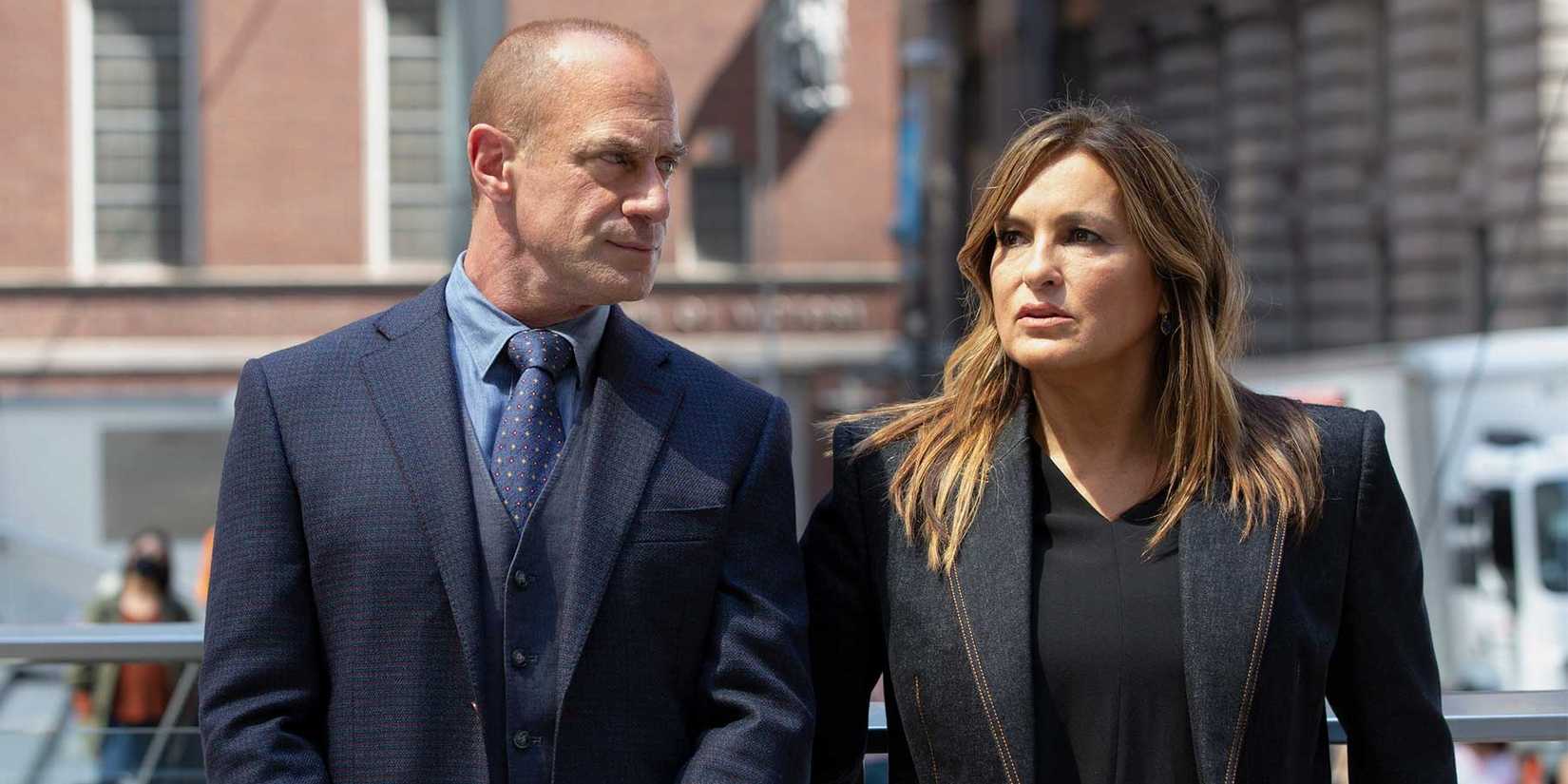 Elliot Stabler, wearing a blue suit, walks beside Olivia Benson in a black suit from Law & Order