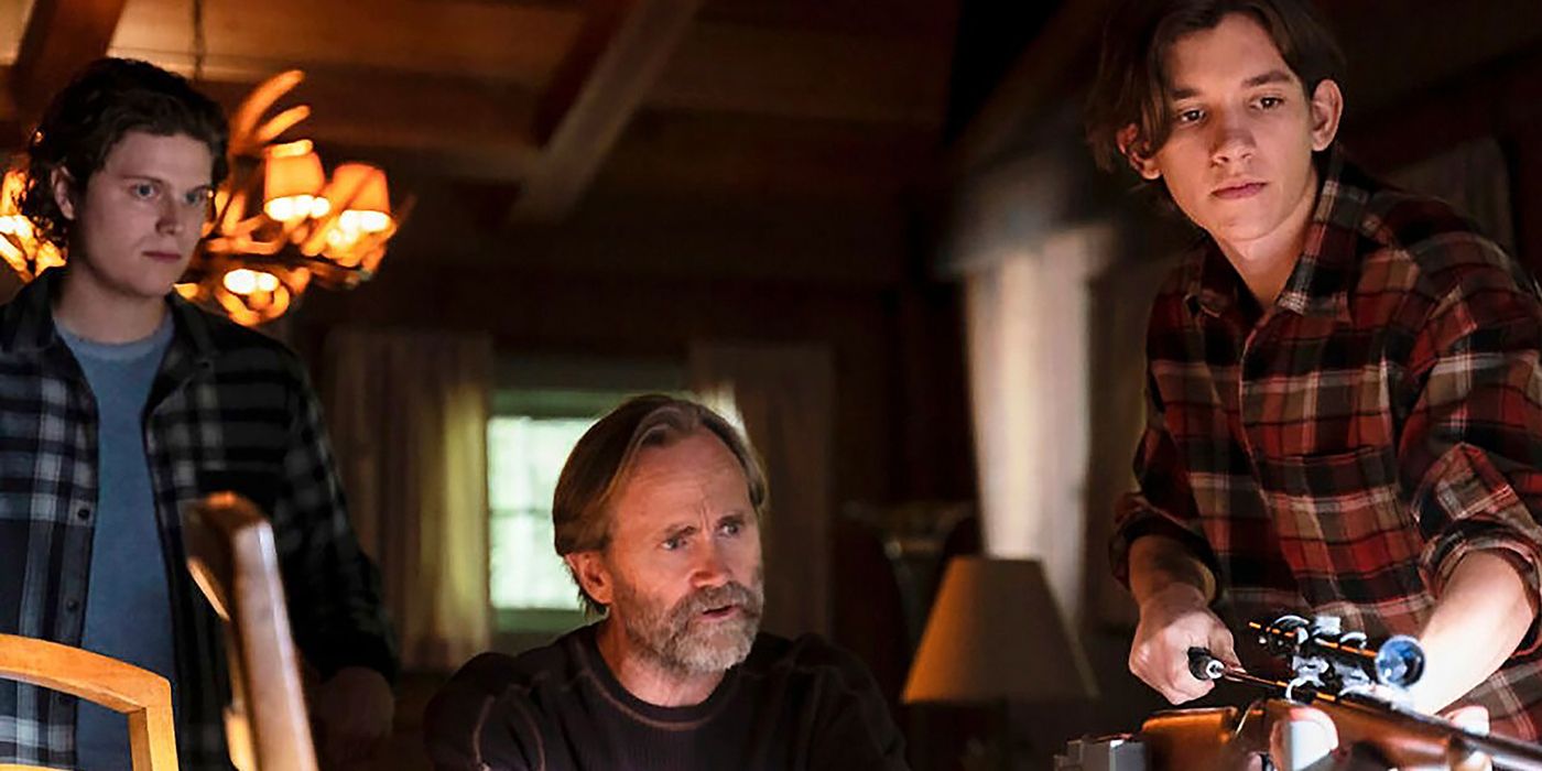 Teenage Colter and Russell at the table in a cabin with their father in a flashback scene in Tracker.