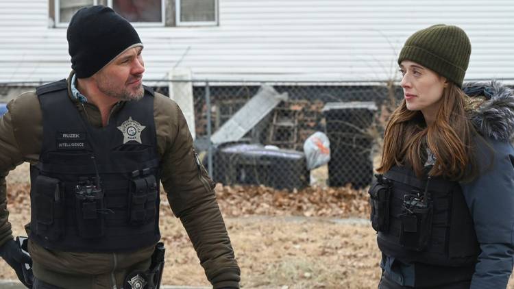 Adam Ruzek and Kim Burgess, both wearing winter coats and beanies, walk together on Chicago PD
