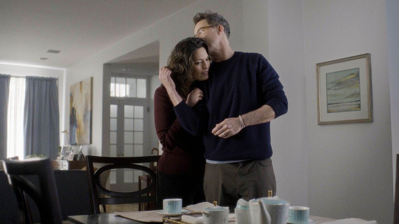 Phillip, played by Tom Cavanaugh, embraces Isobel in their living room on the TV show FBI