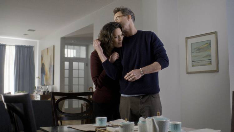 Phillip, played by Tom Cavanaugh, embraces Isobel in their living room on the TV show FBI