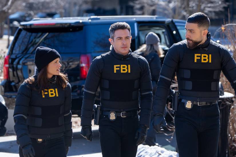 Maggie Bell, Stuart Scola and OA Zidan all wearing black FBI gear in front of an SUV on FBI TV show