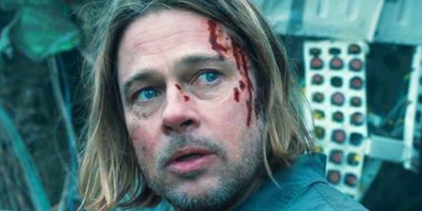 Gerry Lane (Brad Pitt) has blood running down his face and looks worried as he looks behind him in World War Z.