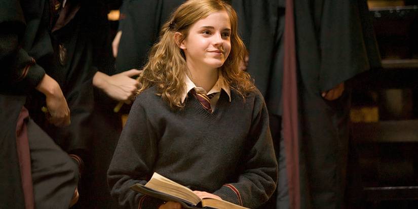 Hermione Granger holding a book and smiling in the movie Harry Potter and the Goblet of Fire