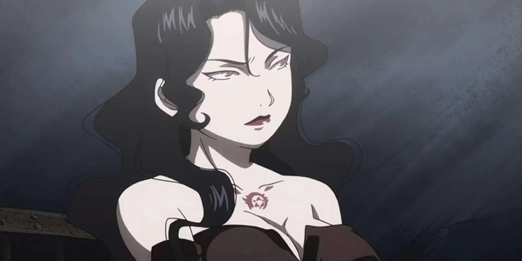 Lust makes a serious face in a dark room.