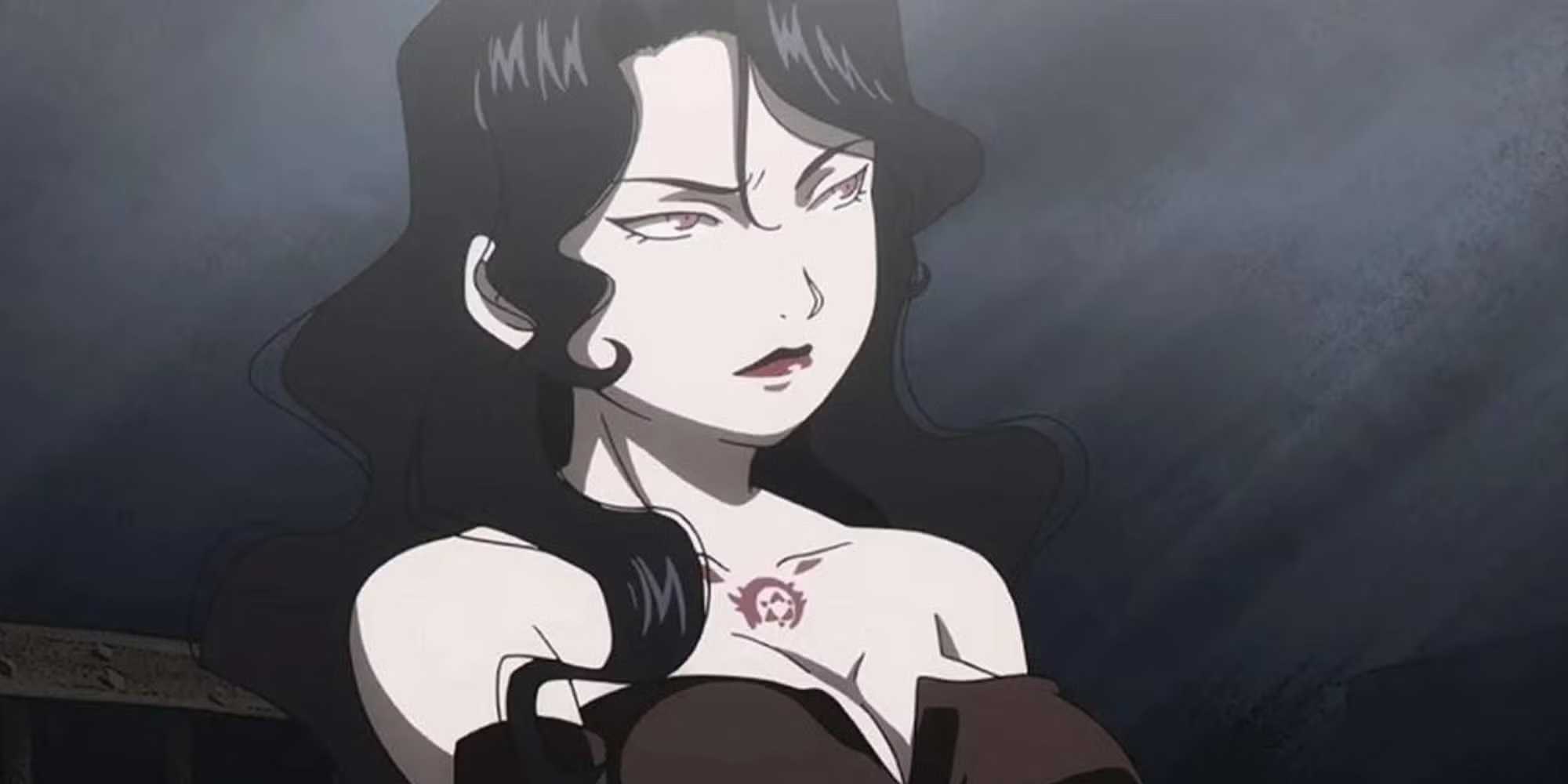 Lust makes a serious face in a dark room.