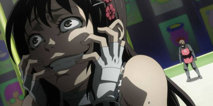 Minatsuki Takami is clutching at her face and giving a deranged smile in Deadman Wonderland as someone stands behind her and looks down.