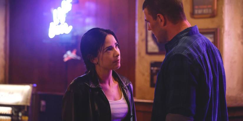 Lala, wearing a black leather jacket and striped shirt, looks up at Gibbs in NCIS: Origins finale.
