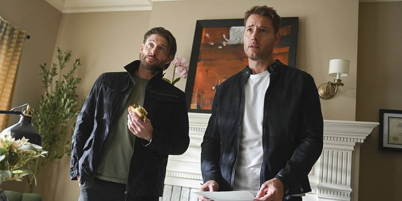Russell Shaw and Colter Shaw stand in a living room while Russell eats a sandwich in Tracker TV show