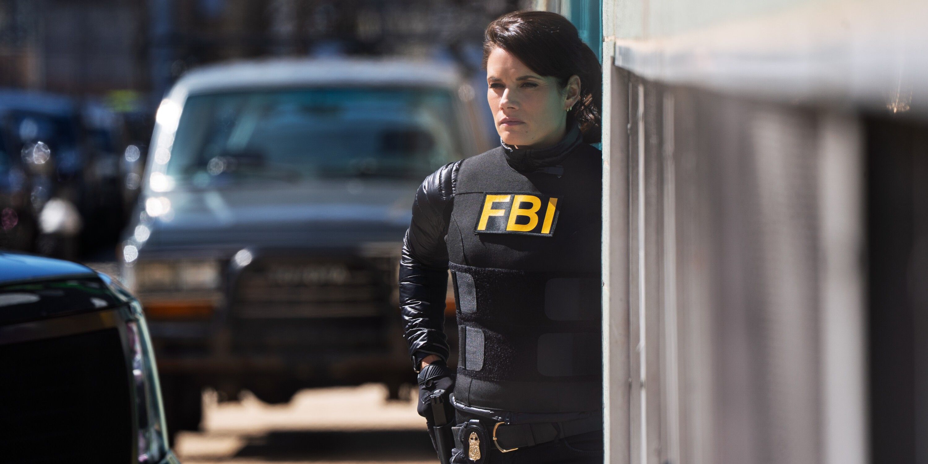Maggie Bell, played by Missy Peregrym, stands on a street corner in black FBI tactical gear on FBI