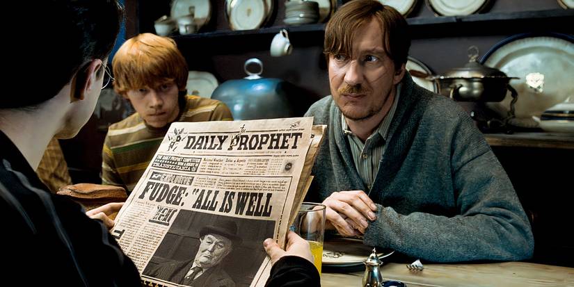 Harry Potter reading a newspaper at a table with Ron Weasley, Remus Lupine at Harry Potter and the Order of Phoenix