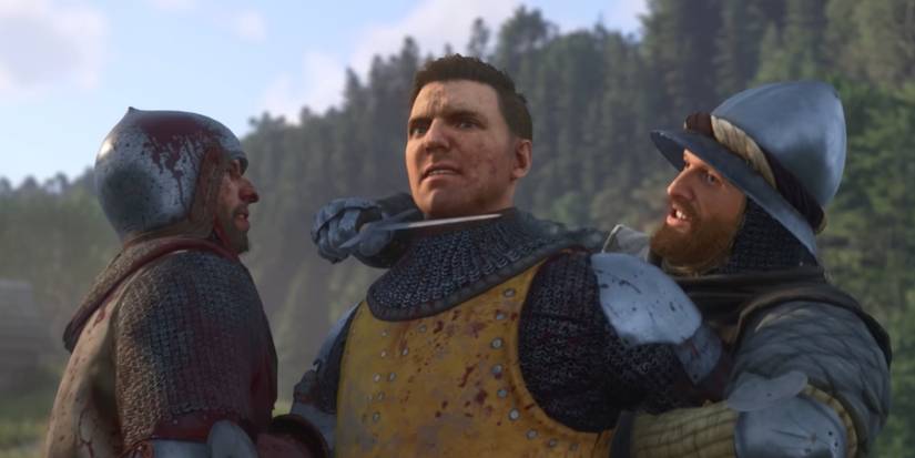 A bloodied Henry held at knifepoint by soldiers in Kingdom Come: Deliverance II.