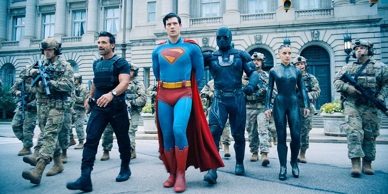 Rick Flagg Sr, Superman, in cuffs, Ultraman behind him, the Engineer next, surrounded by US Army soldiers in Metropolis from Superman 2025.