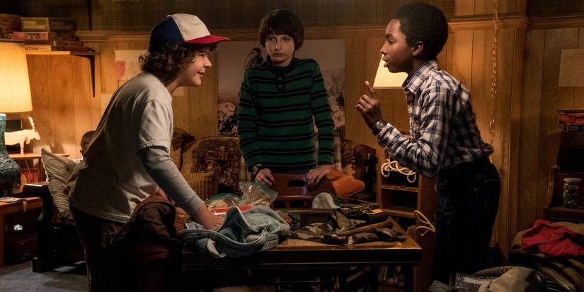 Dustin, Will, Lucas fighting over the DnD game in the basement