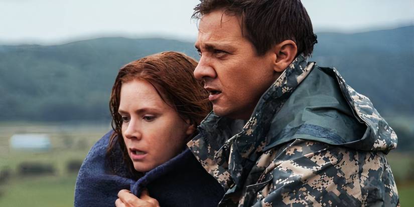 Jeremy Renner wraps a blanket around Amy Adams in Arrival.
