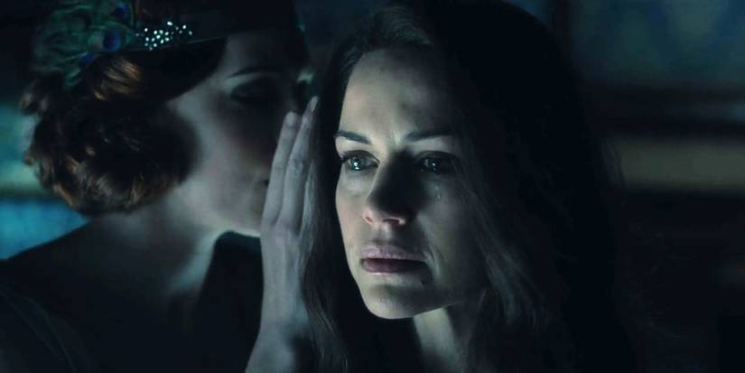 Katie Parker as Poppy whispering in Carla Gugino as Olivia's ear in The Haunting of Hill House