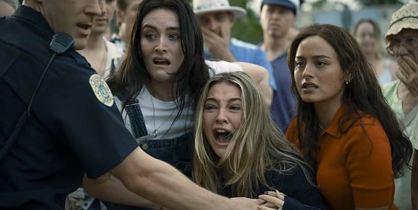 Ava, Stevie and a policeman hold back a grieving Danica at an offscreen crime scene.