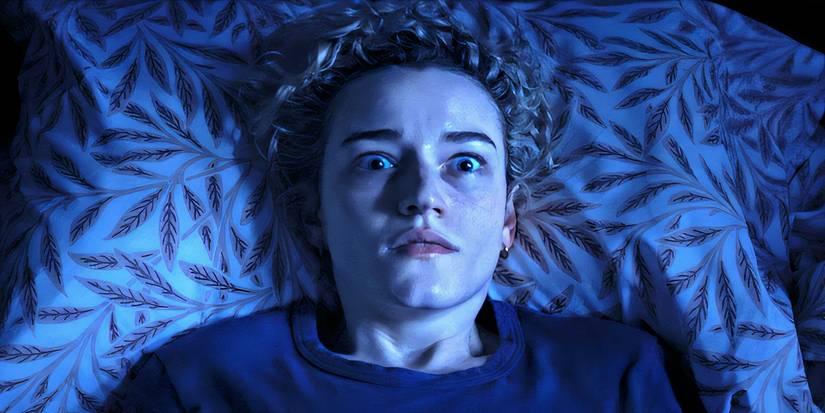 Julia Garner is lying in a bed of arms