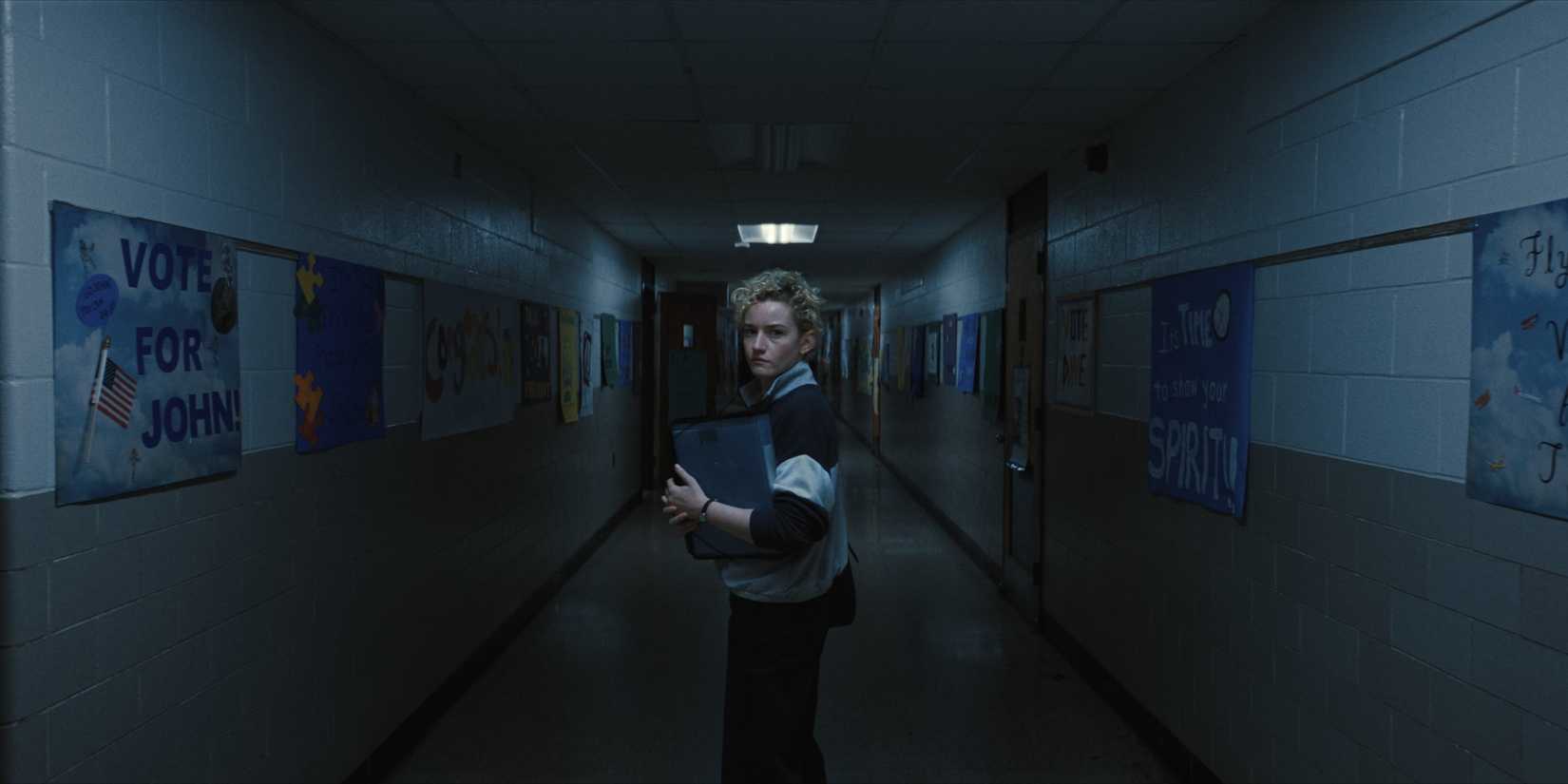 Julia Garner explores a dark school corridor in a dream sequence - Weapons