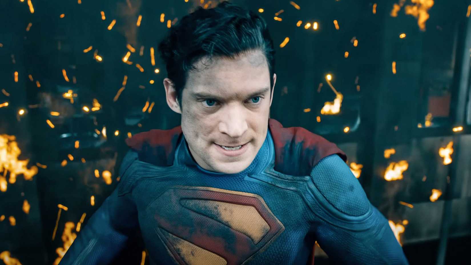 David Corenswet as Superman with a burnt building behind him