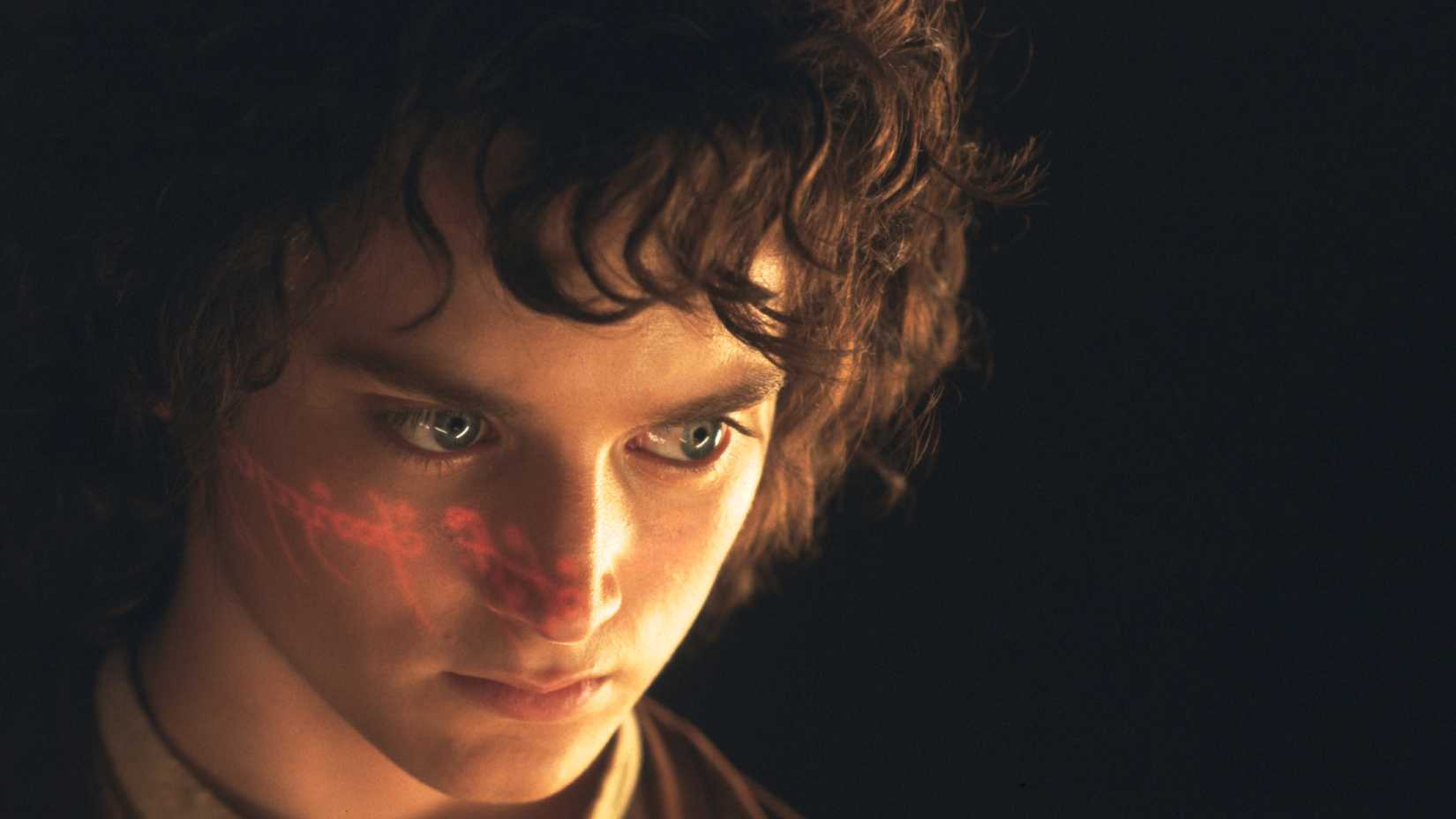 Frodo Baggins (Elijah Wood) with the dark language of Mordor illuminated on his face in Lord of the Rings