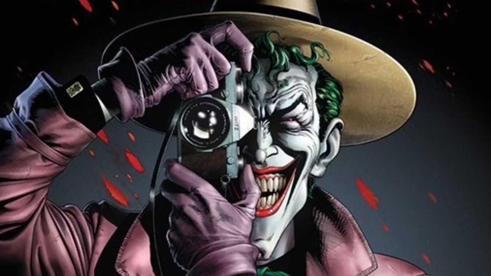 Joker grins as he aims a camera at the viewer in The Killing Joke
