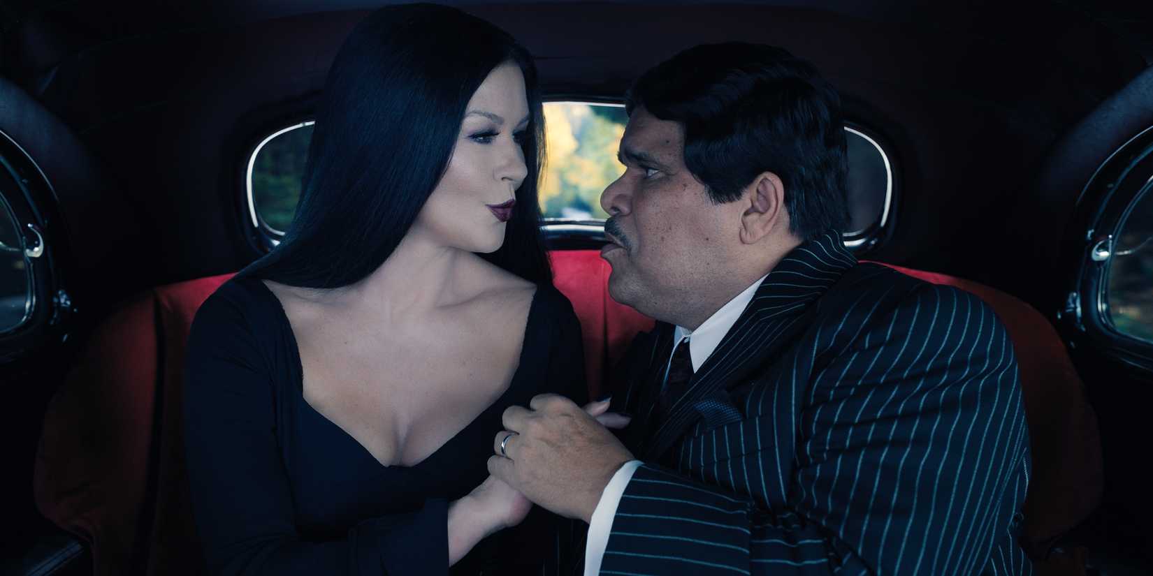 Morticia (Catherine Zeta-Jones) and Gomez Addams (Luis Guzmán) singing to each other in Wednesday Season 1.