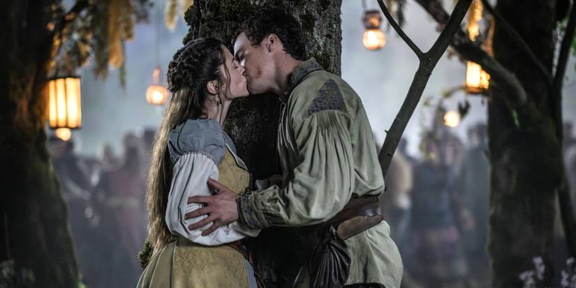 Robert of Locksley and Marian kissing behind a tree at a wedding in Robin Hood